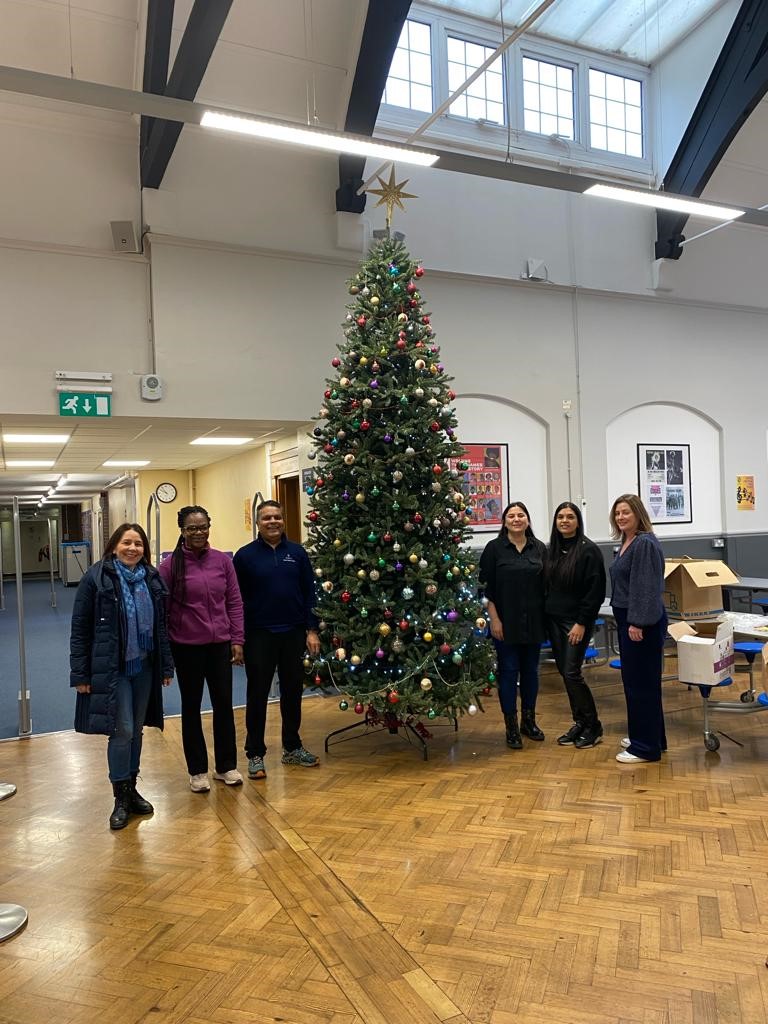 LPF members standing next to the Christmas tree in the Small Hall