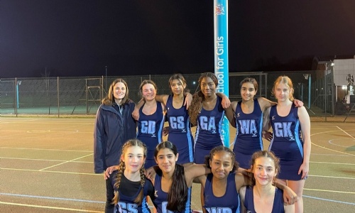 U14 netball girl team posing as a team, along with PE teacher