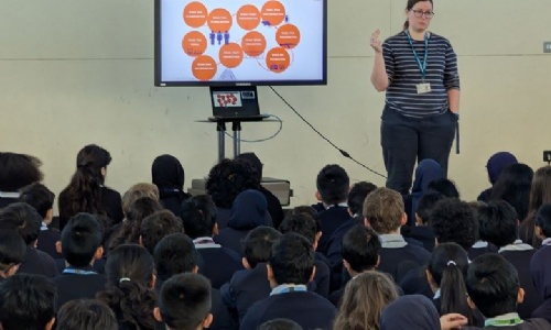 Teacher presenting the Holocaust Memorial Assembly in front of Year 7 students