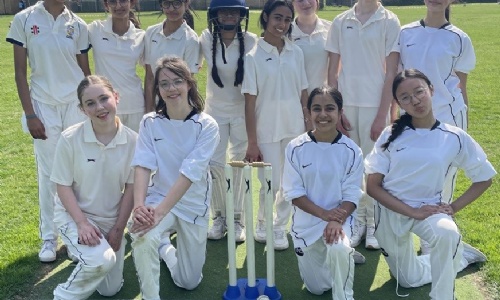 U13 girl cricket team posing on the lawn