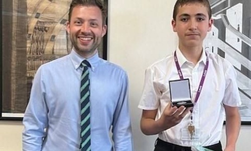 Mr Gilford and Taha posing with his medal