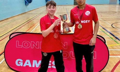 2 students holding a cup