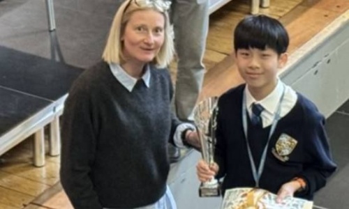 The winner posing with a teacher